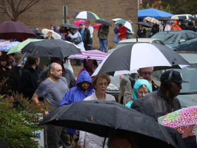 Virginia residents line up to vote in the pouring rain at Robious Middle School, November 6, 2018, in Midlothian, Virginia.