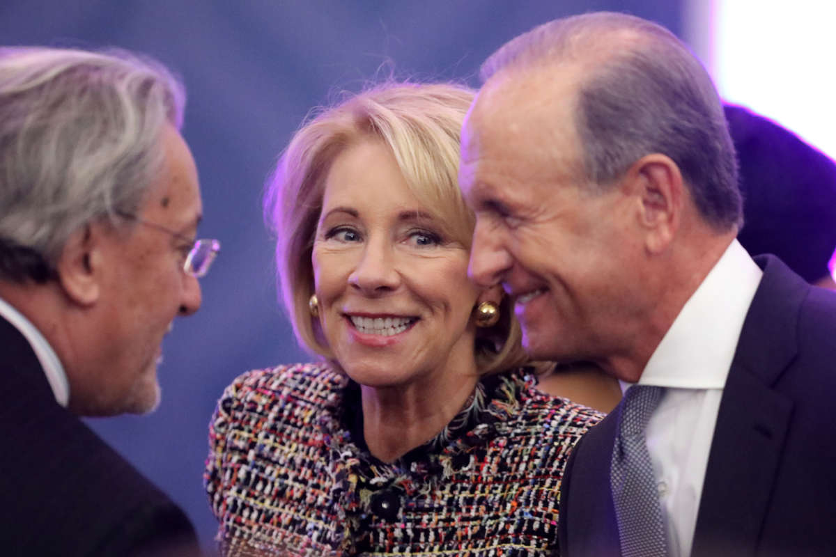 U.S. Education Secretary Betsy DeVos and her husband Dick DeVos, right, greet fellow guests in the Dean Acheson Auditorium at the Department of State's Harry S. Truman building, March 7, 2019, in Washington, D.C.