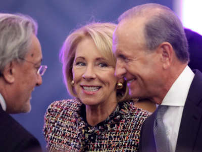U.S. Education Secretary Betsy DeVos and her husband Dick DeVos, right, greet fellow guests in the Dean Acheson Auditorium at the Department of State's Harry S. Truman building, March 7, 2019, in Washington, D.C.