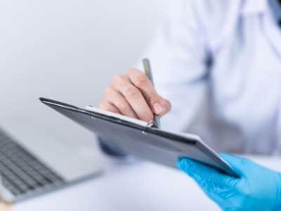 A doctor writing on a clipboard