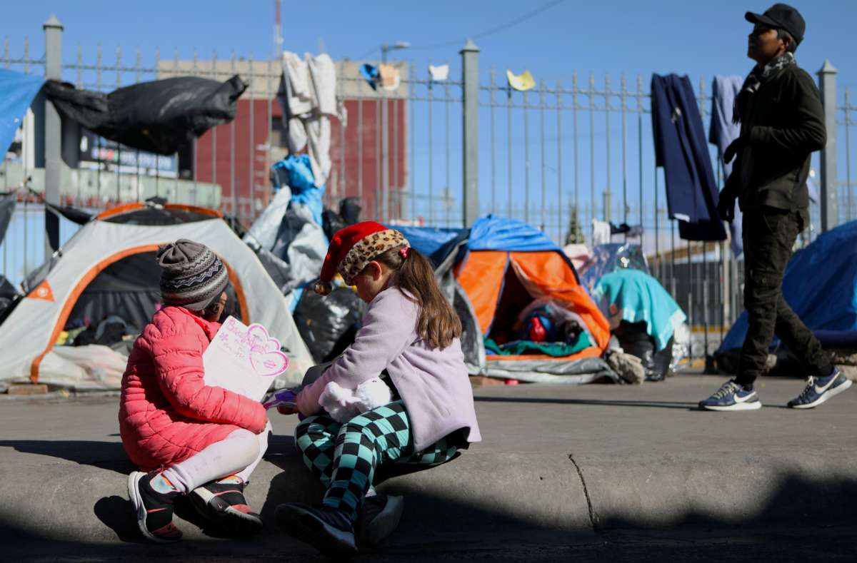 Migrant children play with Christmas presents -sent by fans of the FC Juarez football team- next to the Paso del Norte-Santa Fe international bridge, in Ciudad Juarez, Chihuahua state, Mexico, on December 25, 2019.