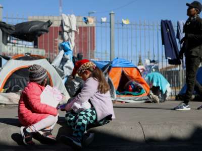 Migrant children play with Christmas presents -sent by fans of the FC Juarez football team- next to the Paso del Norte-Santa Fe international bridge, in Ciudad Juarez, Chihuahua state, Mexico, on December 25, 2019.