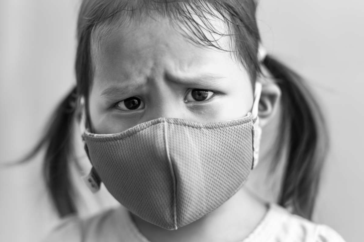 A young girl wears a face mask