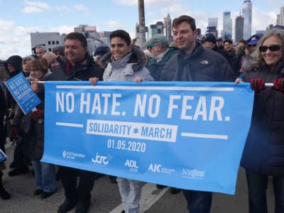 Activists carry a sign reading "NO HATE. NO FEAR" during a protest