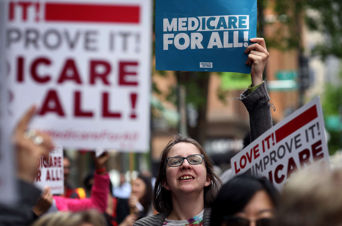 A protester holds a sign supporting medicare for all