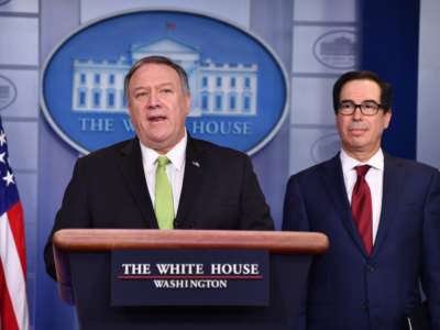Mike Pompeo stands at a podium next to Steve Mnuchin