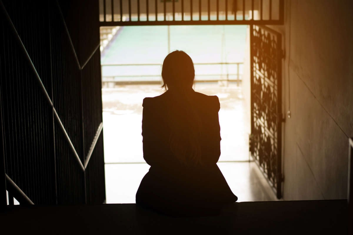 Girl sitting on steps in silhouette