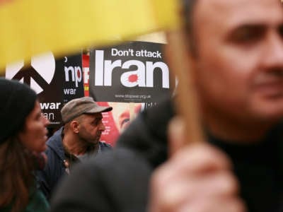 A person holds a sign reading "don't attack Iran" during a protest