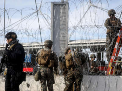 A U.S. Customs and Border Protection agent stands watch as U.S. troops set up concertina wire at the San Ysidro port of entry during a "large-scale operational readiness exercise" which briefly closed the border crossing on November 22, 2018, in Tijuana, Mexico.