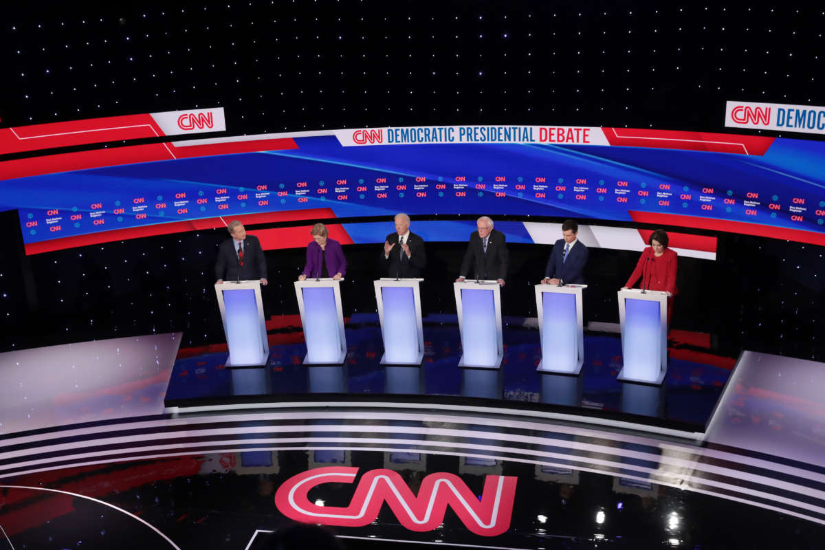 Democratic presidential candidates stand behind their respective podiums on stage