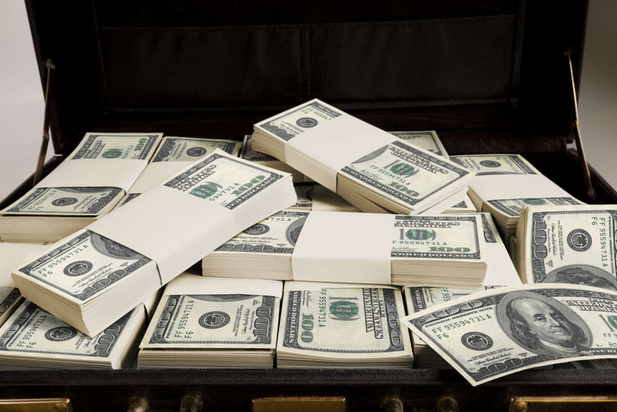Money is piled into a briefcase