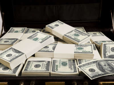 Money is piled into a briefcase
