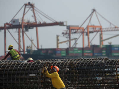 Workers check steel bars at the International Container Terminal Services Incorporated (ICTSI) port in Manila, Philippines, April 18, 2011.