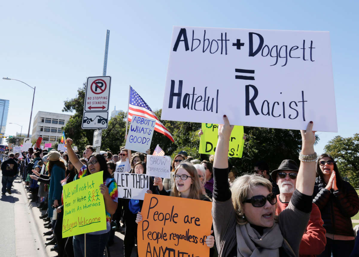 Protesters demonstrate against Texas Governor Greg Abbott's anti-refugee policies in 2015.