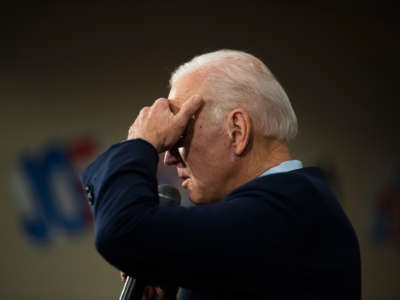 Joe Biden shields his face from light