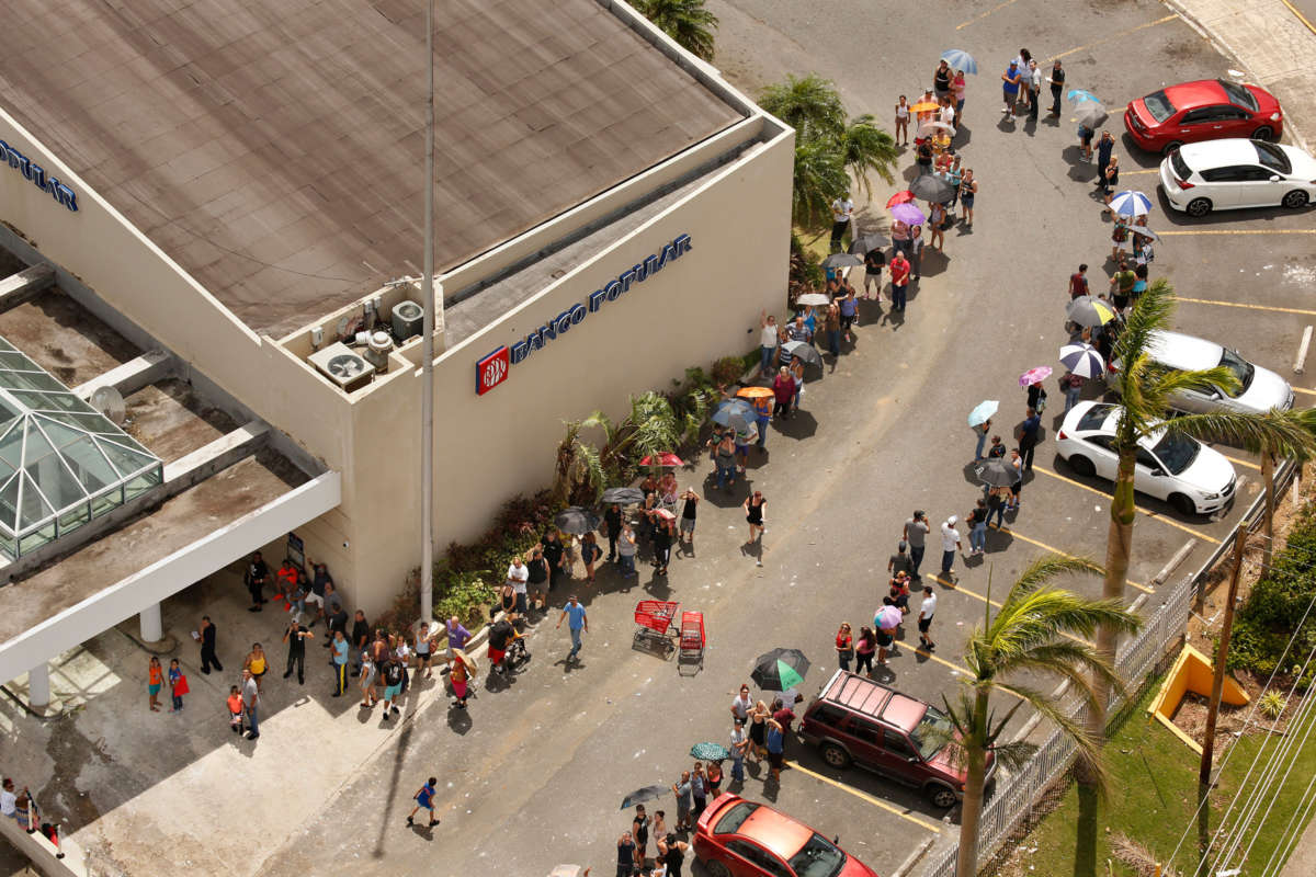 A line of people wraps around the Banco Popular in San Juan on September 25, 2017, nearly one week after Hurricane Maria devastated the island of Puerto Rico.