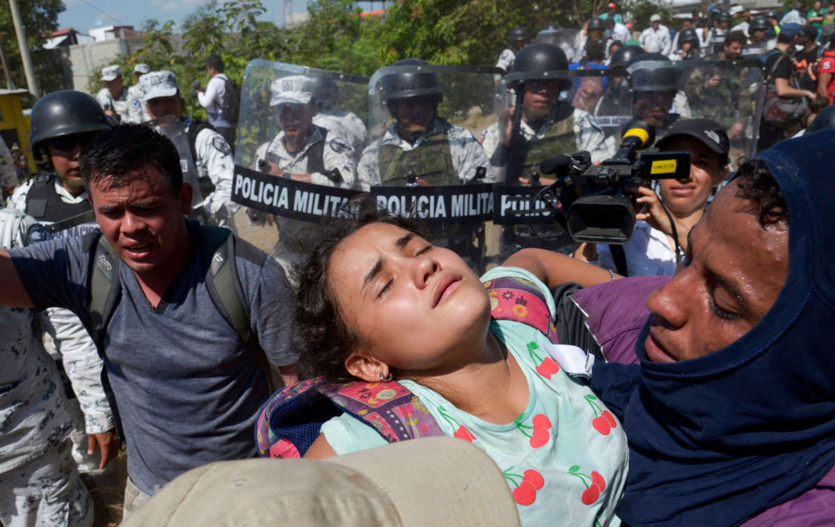 A Central American migrant — part of a caravan to the U.S. made up mostly of Hondurans — carries a girl after encountering Mexican security forces in Ciudad Hidalgo, Mexico, on January 20, 2020.