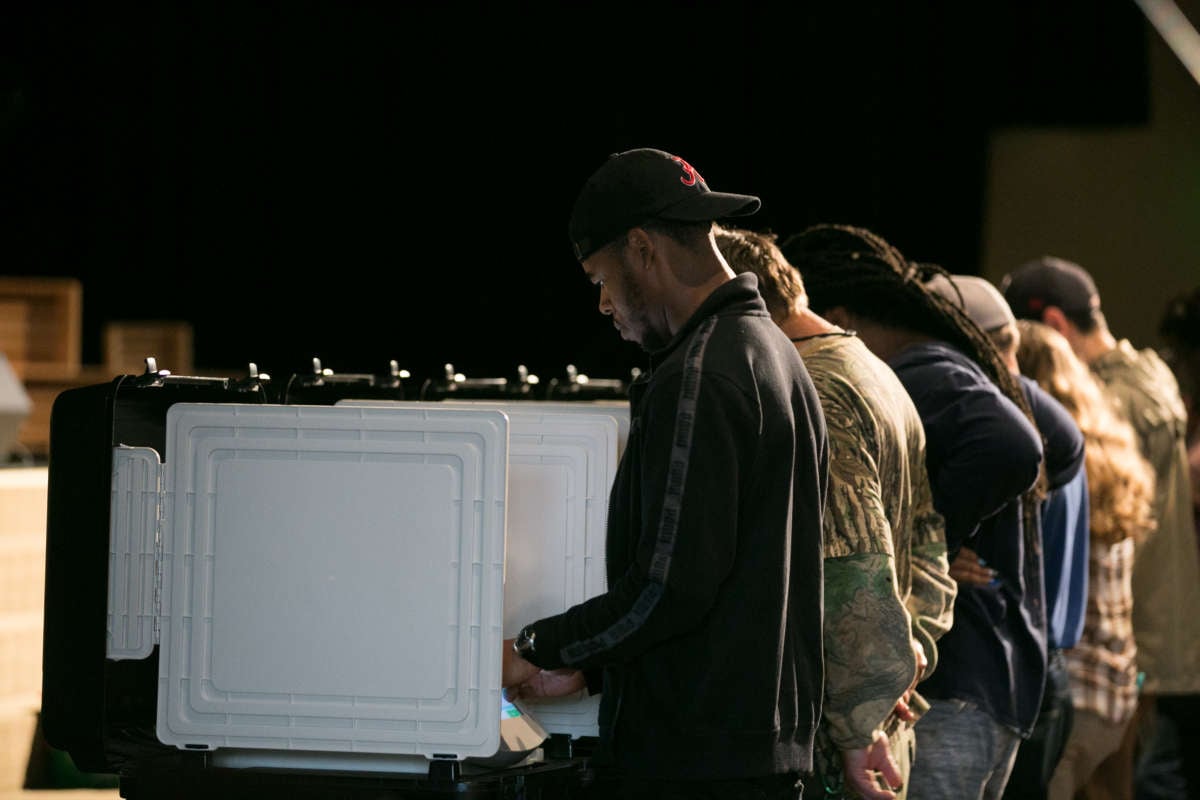 People stand at their respective booths to cast their votes