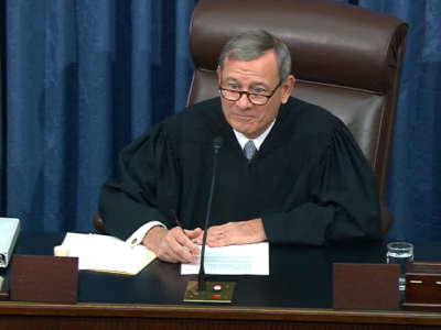 Justice Roberts sits at a desk during a hearing
