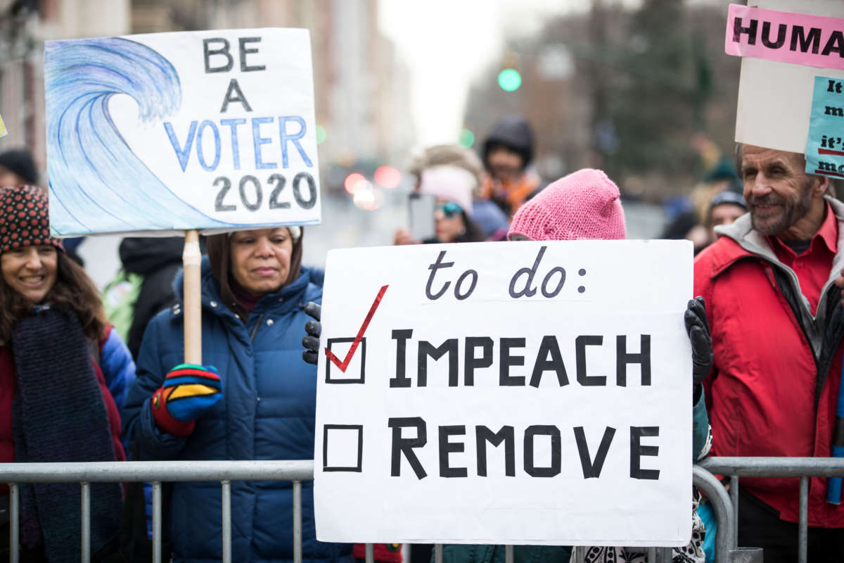 Marchers hold signs as they wait to start marching past Trump International Tower during the Woman's March in the borough of Manhattan in New York on January 18, 2020.