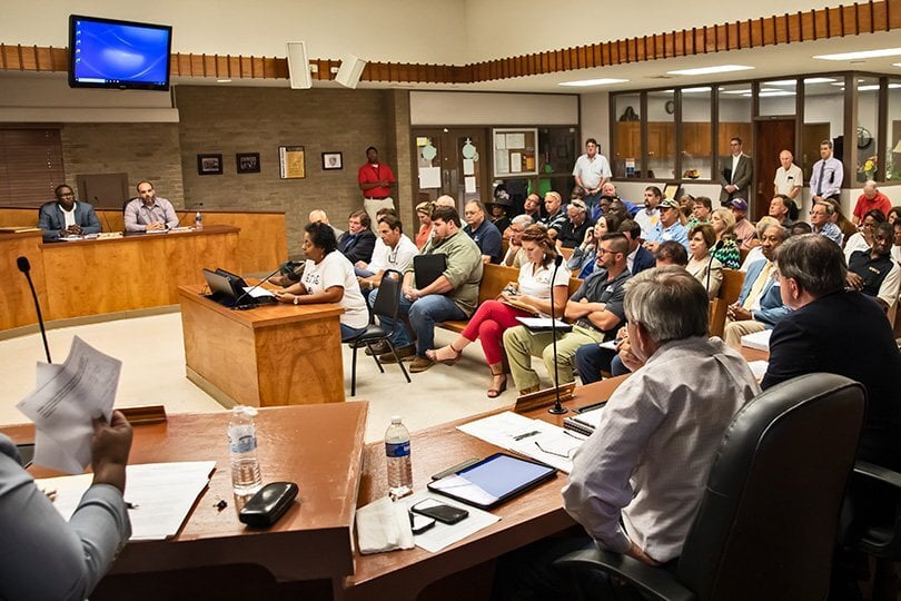 People sit in attendance at a hearing