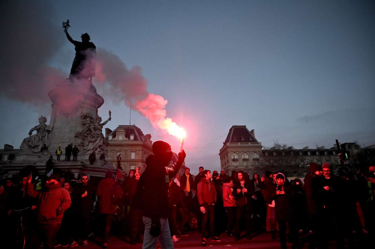 Protesters light flares during a demonstration in Paris, on January 11, 2020, as part of a nationwide multi-sector strike against the French government's pensions overhaul.