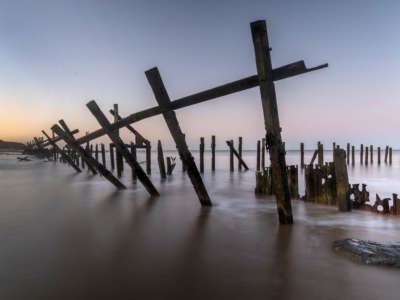 Waves crash against destroyed sea defenses in the coastal village of Happisburgh on January 15, 2020, in Great Yarmouth, United Kingdom. The effects of global climate change causing storms and sea swells has seen the East Coast of the United Kingdom lose up to one meter of coast line each year.