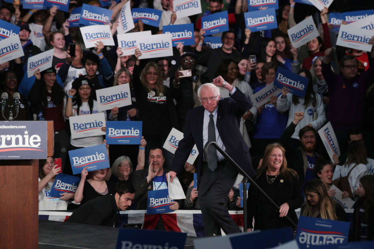 Sen. Bernie Sanders heads on stage with his wife Jane Sanders during his caucus night watch party on February 3, 2020, in Des Moines, Iowa.