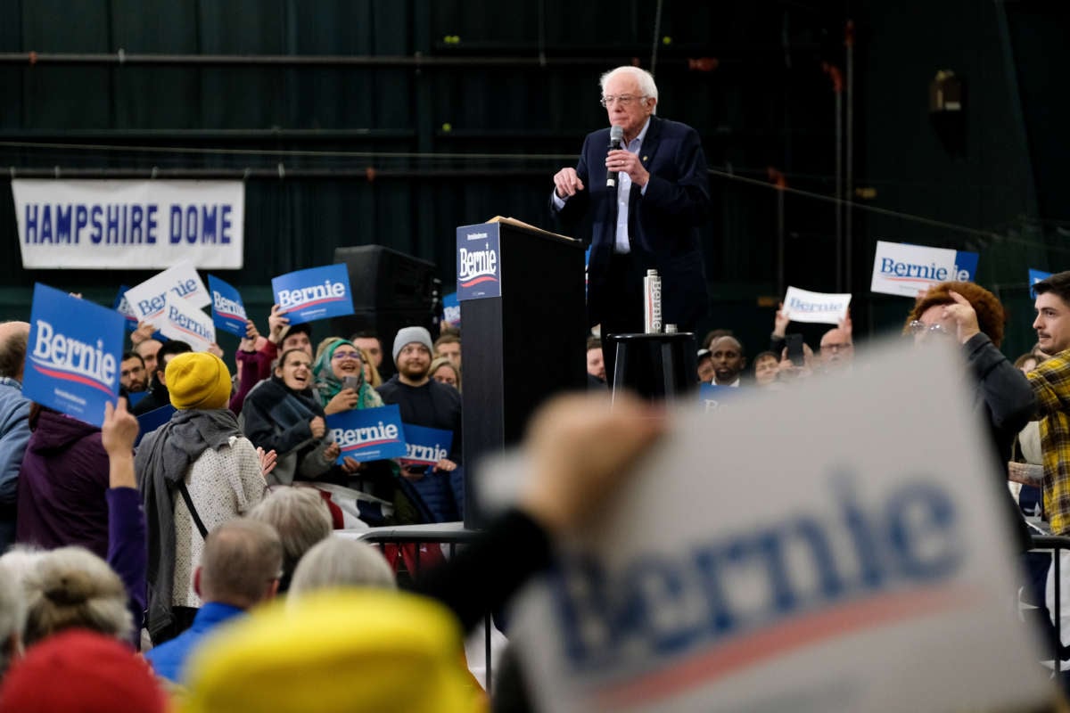 Bernie Sanders speaks at a podium to a crowd of his supporters during a campaign rally