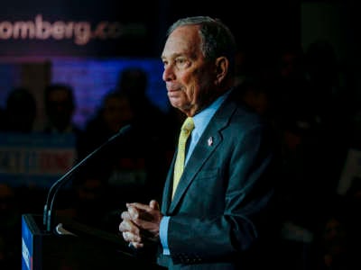 Mike Bloomberg stands at a podium during a campaign rally