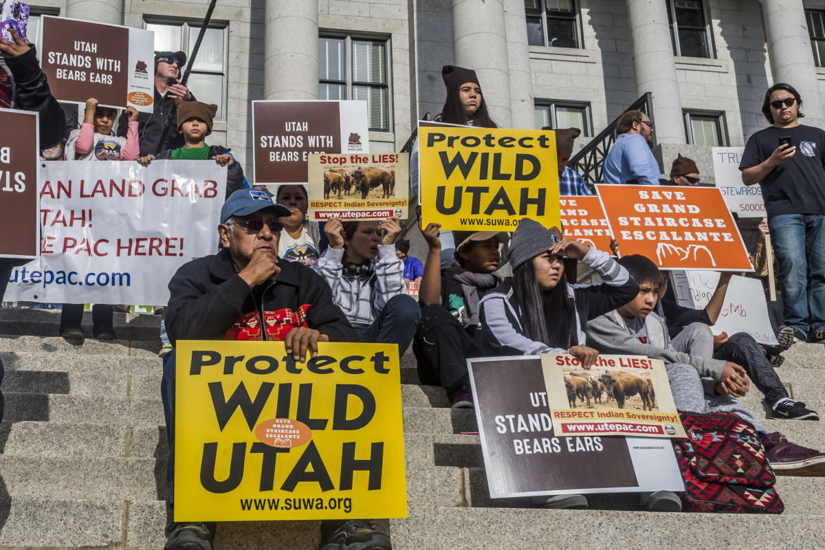 Native American protesters sit on the steps of Utah's Capitol building during a protest to protect the Bears Ears and Grand Staircase Escalante monuments