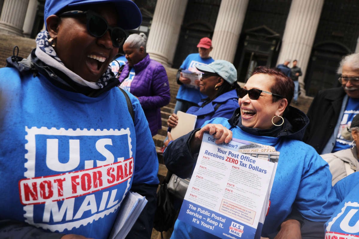 USPS workers cheer during a protest