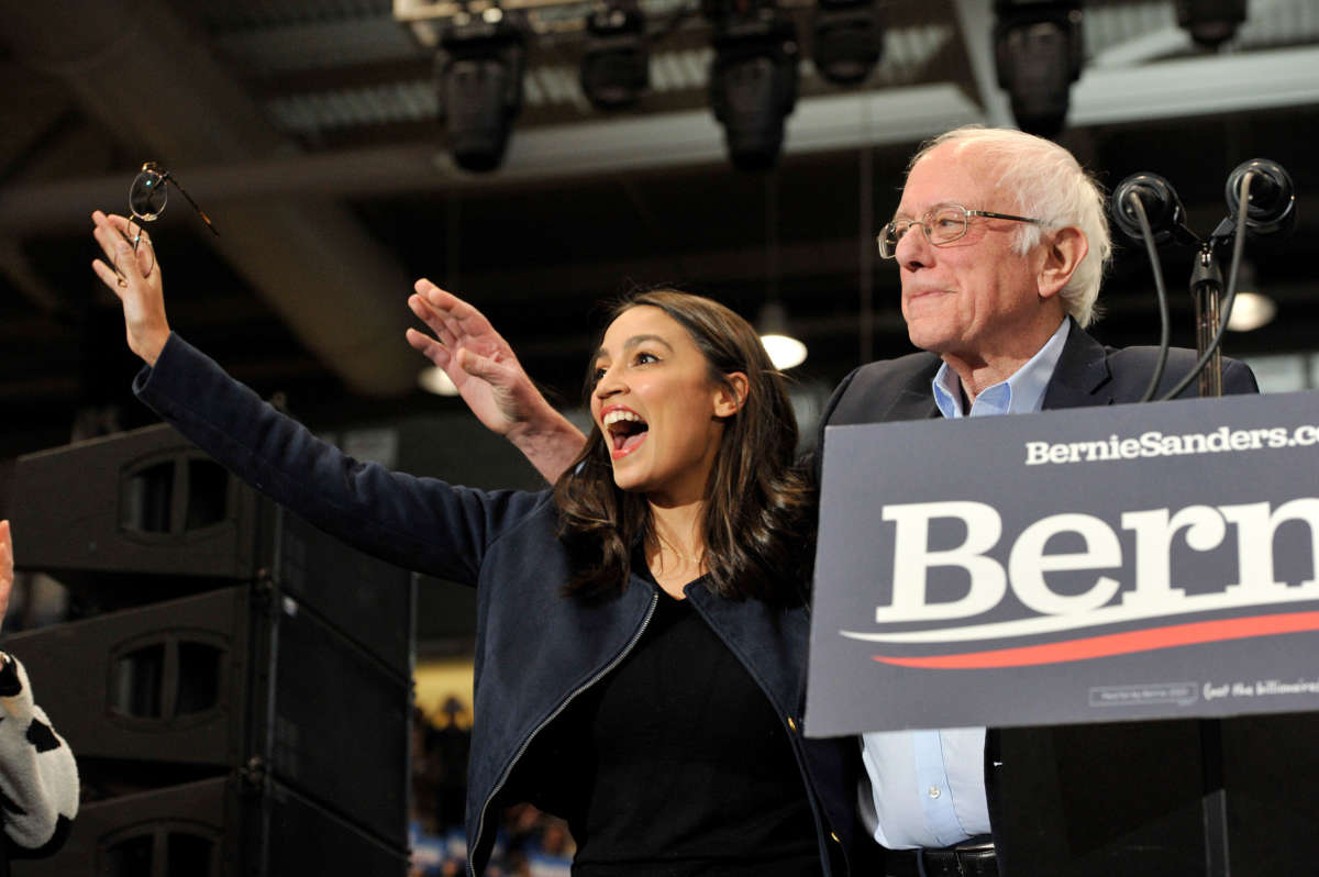 Rep. Alexandria Ocasio-Cortez and Sen. Bernie Sanders wave to his supporters at rally at the University of New Hampshire in Durham, New Hampshire on February 10, 2020.