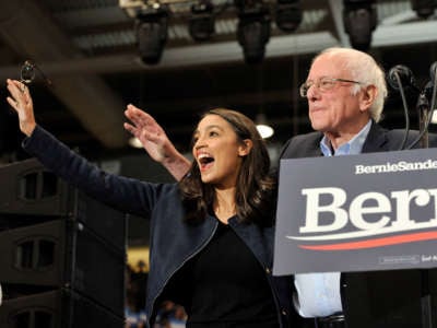 Rep. Alexandria Ocasio-Cortez and Sen. Bernie Sanders wave to his supporters at rally at the University of New Hampshire in Durham, New Hampshire on February 10, 2020.