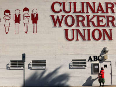 A worker enters the culinary workers union building, labeled as such with large red letters