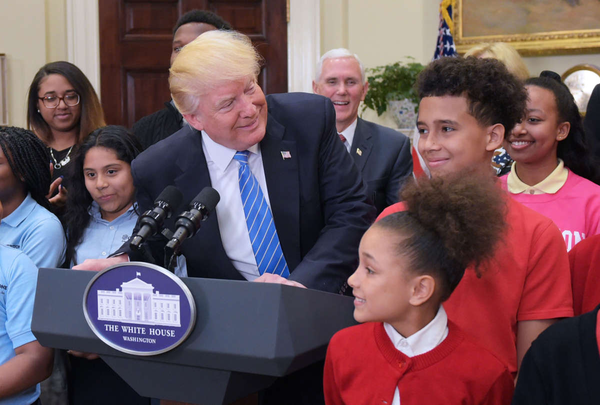 President Trump smiles at students at a school choice event with Education Secretary Betsy DeVos