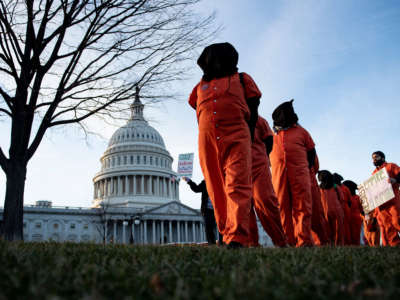 Demonstrators dressed in Guantanamo Bay prisoner uniforms march past Capitol Hill in Washington, D.C, on January 9, 2020, during a rally against war with Iran.