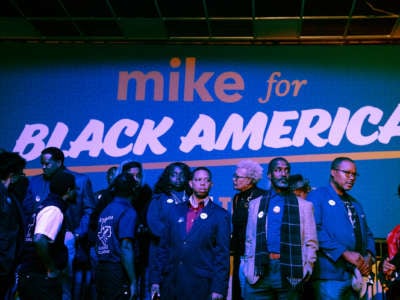 Black people line up under a sign reading "MIKE FOR BLACK AMERICA"