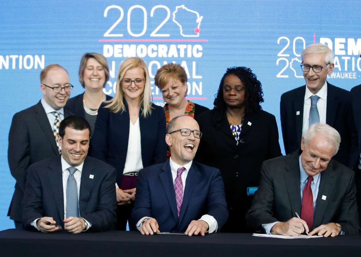 Democratic National Committee members sign a document announcing the selection of Milwaukee as the 2020 Democratic National Convention host city as Wisconsin Governor Tony Evers and DNC Chair Tom Perez look on during a press conference at the Fiserv Forum in Milwaukee, Wisconsin, on March 11, 2019.
