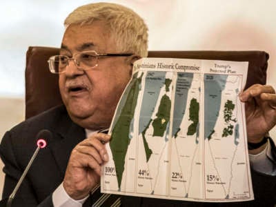 Palestinian president Mahmoud Abbas holds a placard showing a series of maps of Palestine at the Arab League headquarters in the Egyptian capital Cairo on February 1, 2020.