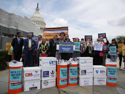 House Democrats speak during a news conference surrounded by oversized prop pill bottles