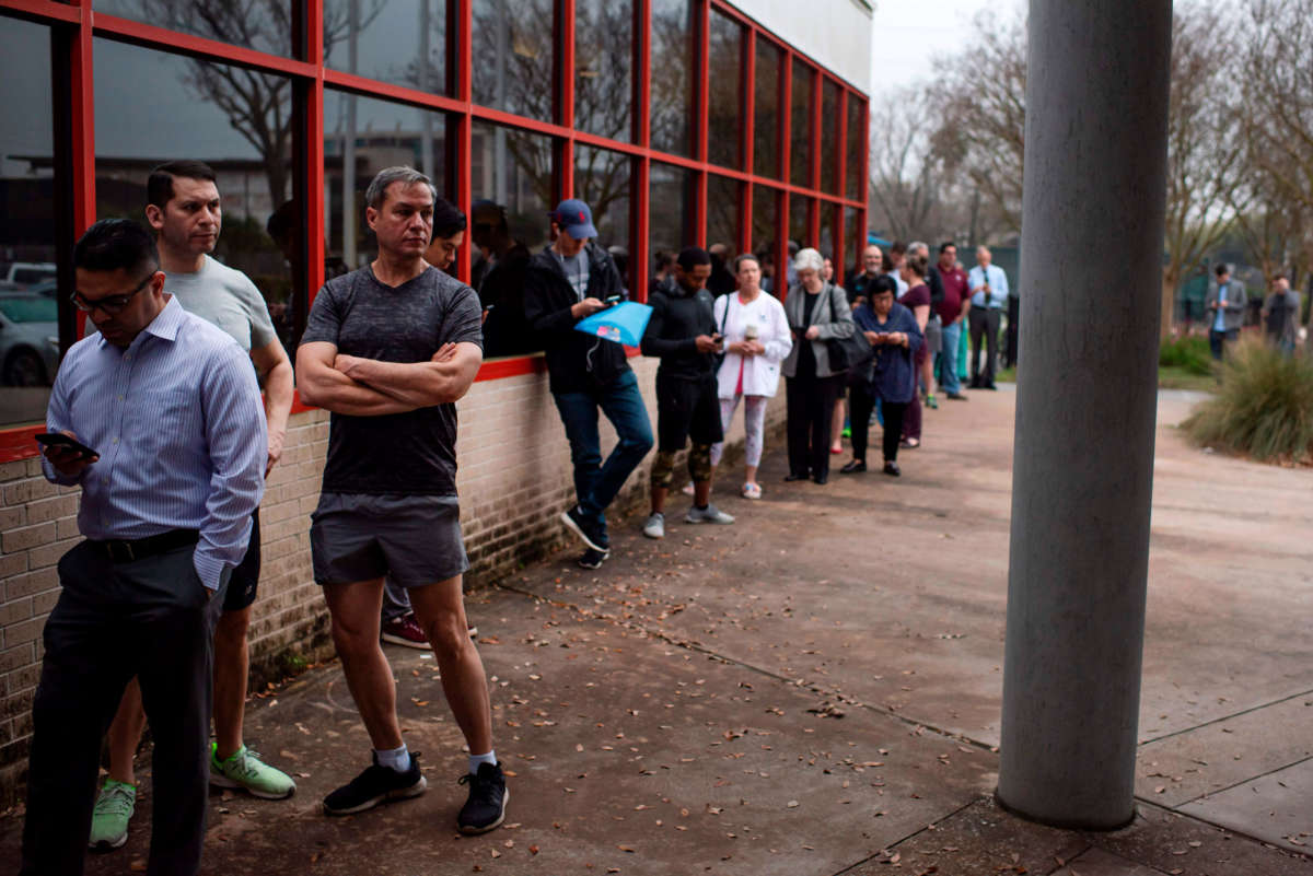 Voters wait in line to cast their ballots during the presidential primary in Houston, Texas, on Super Tuesday, March 3, 2020.