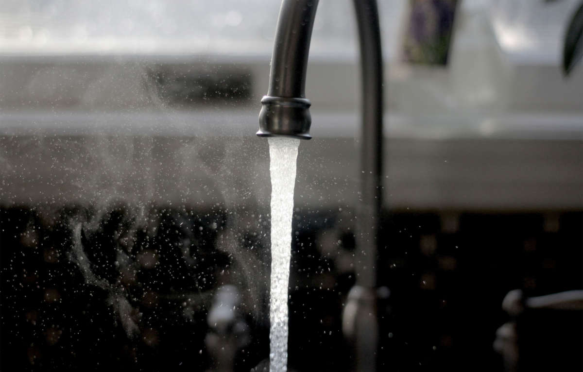 Water pours from a kitchen sink faucet