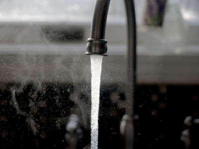 Water pours from a kitchen sink faucet