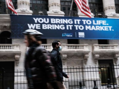 A man in a medical mask walks by the New York Stock Exchange on March 10, 2020, in New York City.