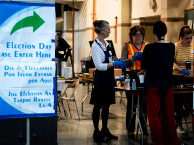 Election workers wait for voters during the Florida primary election at Doris & Phil Sanford Fire Rescue Station Coral Gables in Miami, Florida, on March 17, 2020.