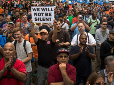 The crowd listens as New York Governor Andrew Cuomo speaks during a rally of hundreds of union members in support of IBEW Local 3 (International Brotherhood of Electrical Workers) at Cadman Plaza Park, September 18, 2017, in the Brooklyn borough of New York City.