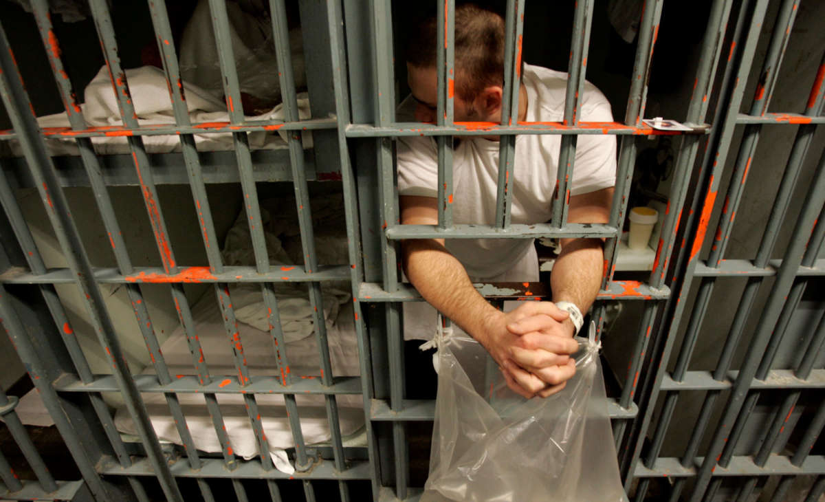 An inmate leans out the bars of his cell at the Men's Central Jail in downtown Los Angeles, October 11, 2005.