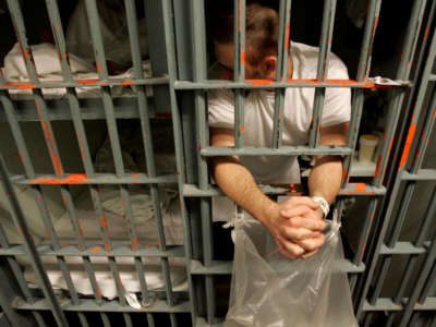 An inmate leans out the bars of his cell at the Men's Central Jail in downtown Los Angeles, October 11, 2005.