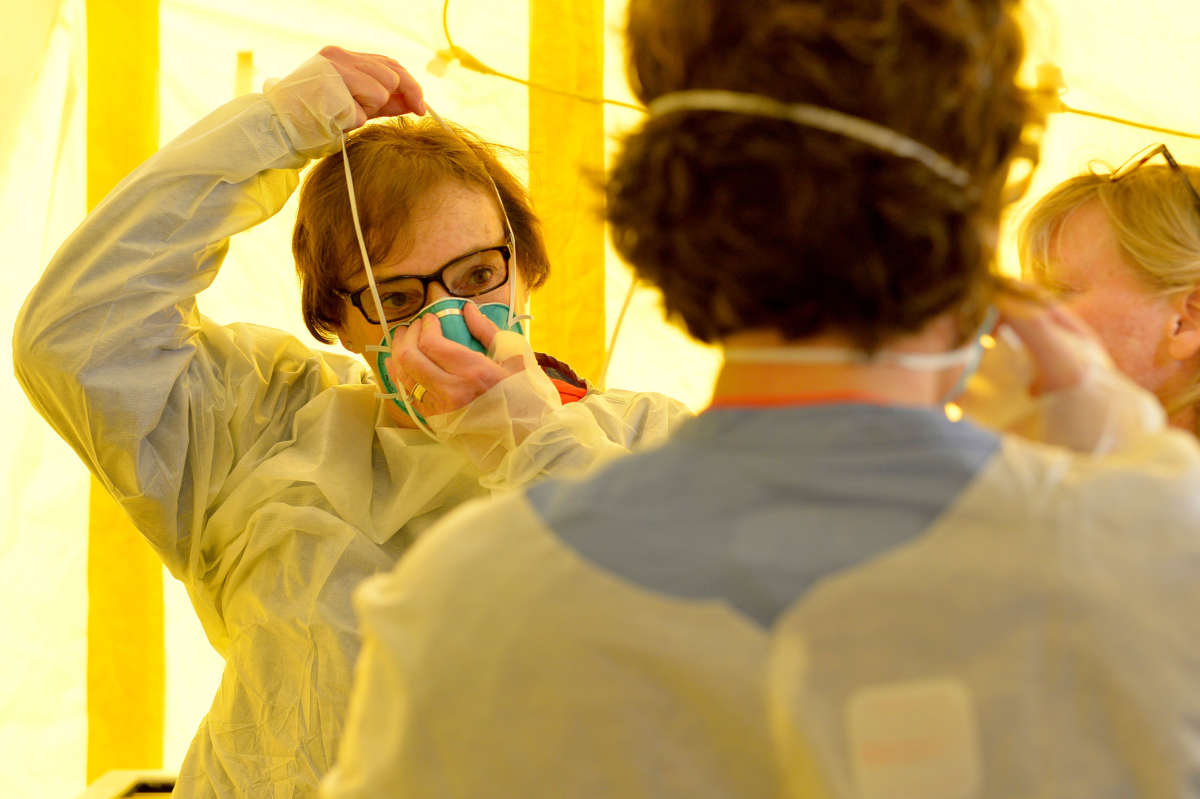 Hospital clinicians get into their protective equipment before testing patients for the coronavirus, COVID-19, at Newton-Wellesley Hospital in Newton, Massachusetts, on March 18, 2020.